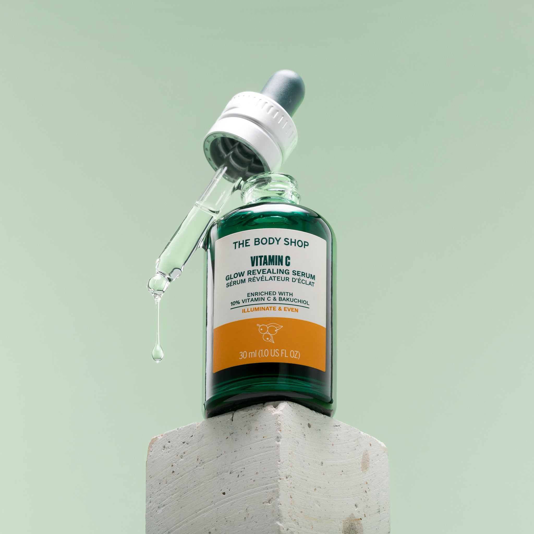 The Body Shop Vitamin C Glow Serum bottle sat on top of a stone block.