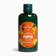 A 250 ml bottle of The Body Shop Pumpkin Bath & Shower Cream, featuring a dark green translucent bottle, a dark green flip-top cap, and a prominent orange circular label with illustrations of pumpkins and the brand name.