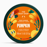The Body Shop Pumpkin Body Scrub in a round dark green tub with a bright orange label featuring pumpkins and autumn leaves.