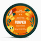 The Body Shop Pumpkin Body Scrub in a round dark green tub with a bright orange label featuring pumpkins and autumn leaves.