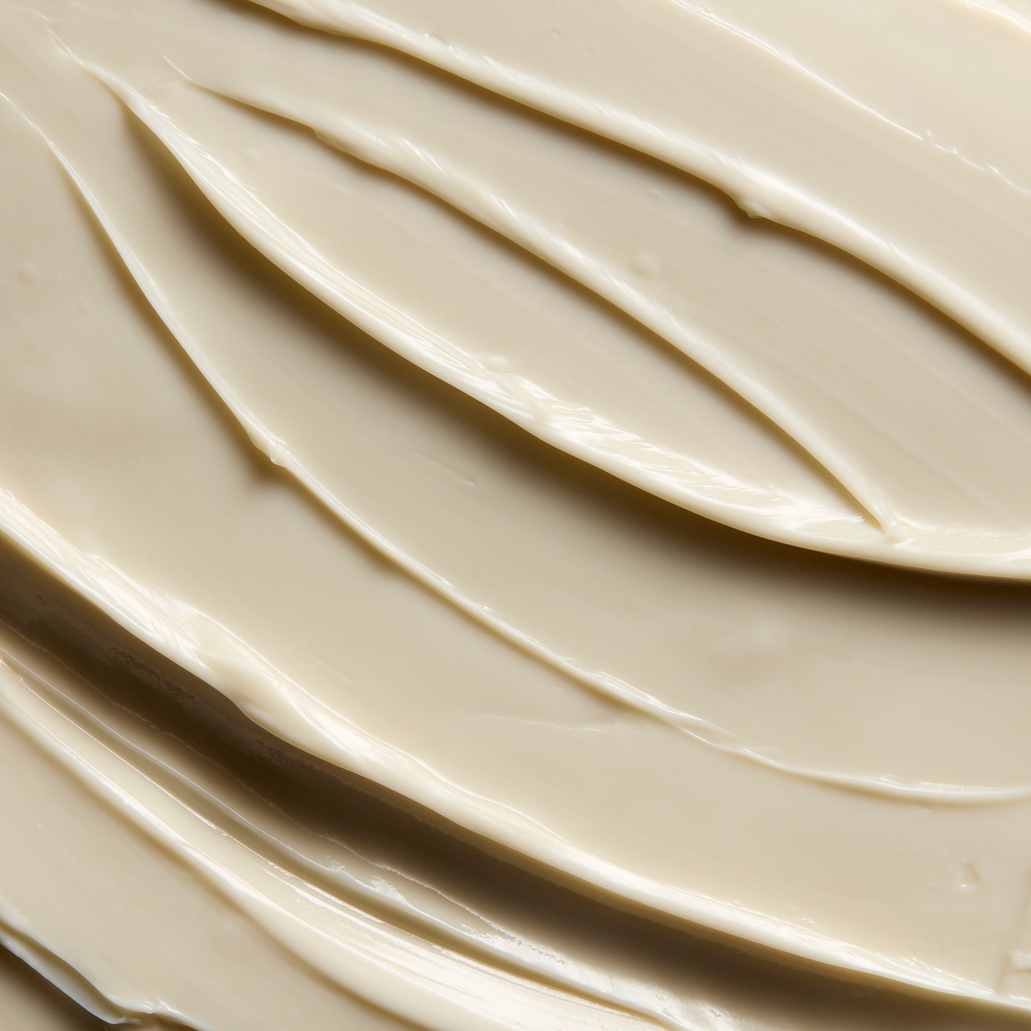 Close-up of smooth Olive body butter cream, showing soft swirls and a rich, creamy texture | The Body Shop