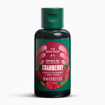 A bottle of The Body Shop Cranberry Shower Gel, 60 ml, featuring a dark green bottle and cap with a label depicting red cranberries on a white background.