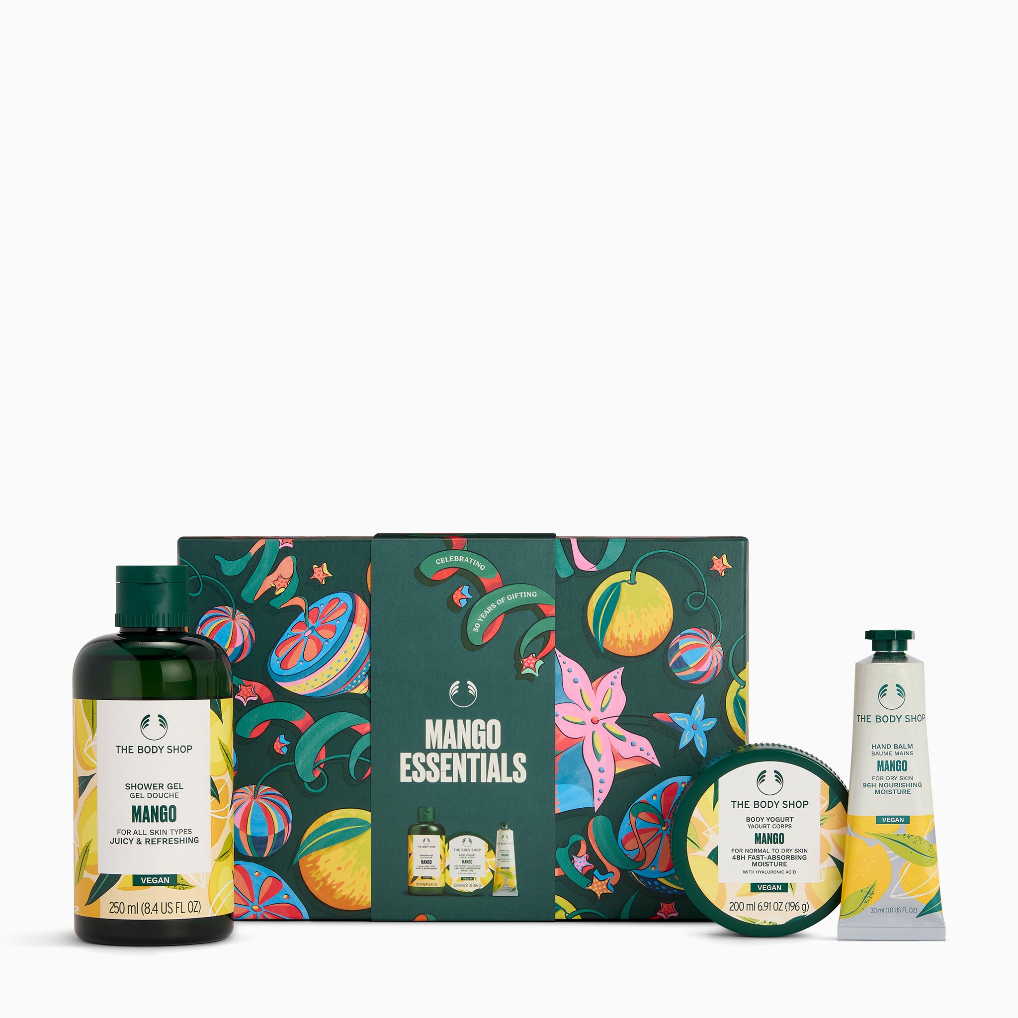 The Body Shop Mango Essentials gift set featuring a shower cream bottle, hand cream tube, bath & body scrub bottle, round tin, and a decorative illustrated gift box on a white background.