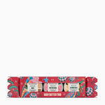 The Body Shop Body Butter Trio in a decorative red Christmas cracker box with colorful illustrations and labels for Shea, Butter Rose, and Almond Milk body butters, shown on a white background.
