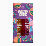 The front of a purple retail box for a fragrance duo set, with colorful illustrated fruit and ribbon graphics and the text 'SWEET ON YOU DUO.' Two perfume mist bottles are visible through the front window: 'you, me bubble tea' and 'cotton candy kiss.