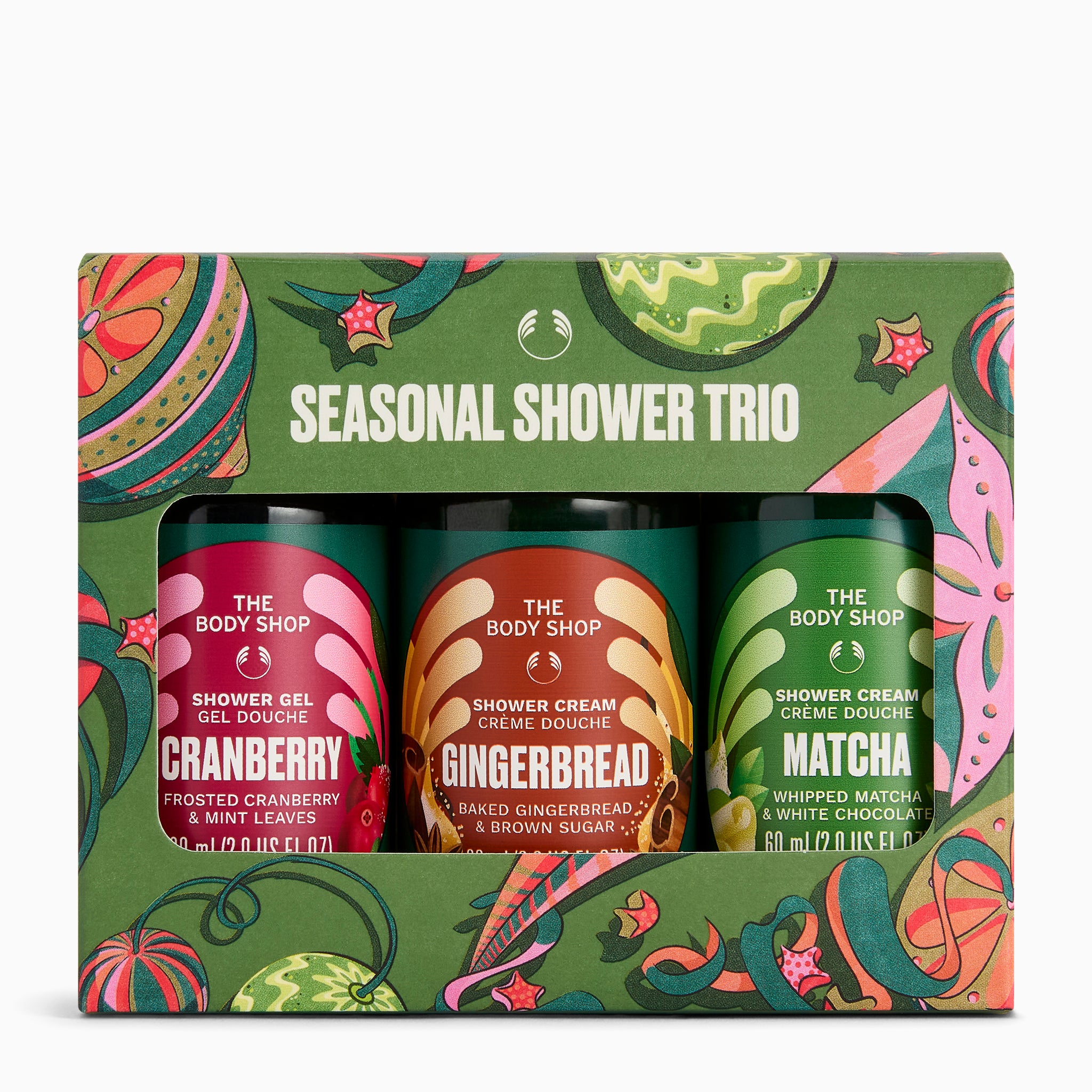The Body Shop Seasonal Shower Trio gift set in a bright green patterned box, containing three small shower gel bottles labelled Cranberry, Gingerbread, and Matcha.