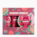 The Body Shop Cranberry Favourites gift set, featuring a pink patterned box containing a hand cream, a frosted body butter, and a body lotion. The packaging features festive cranberry and candy cane illustrations.