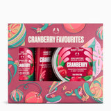 The Body Shop Cranberry Favourites gift set, featuring a pink patterned box containing a hand cream, a frosted body butter, and a body lotion. The packaging features festive cranberry and candy cane illustrations.