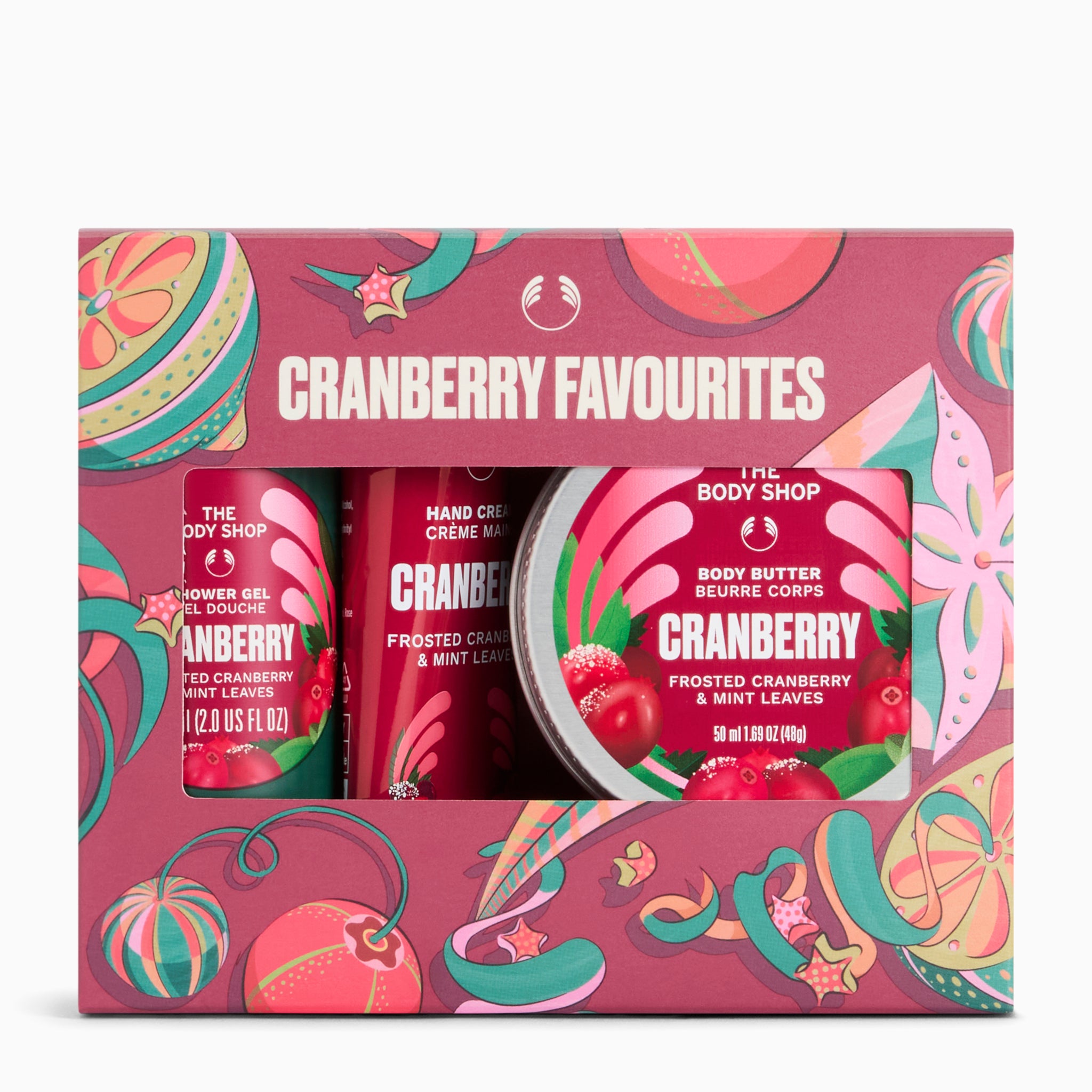 The Body Shop Cranberry Favourites gift set, featuring a pink patterned box containing a hand cream, a frosted body butter, and a body lotion. The packaging features festive cranberry and candy cane illustrations.