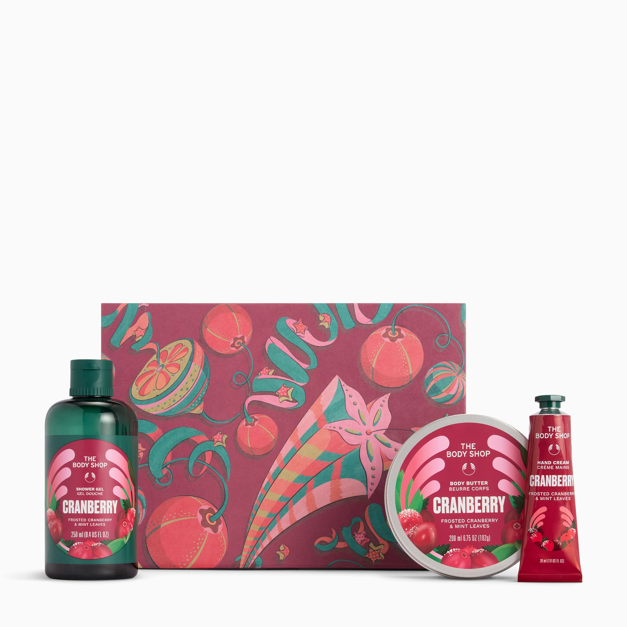 The Body Shop Cranberry & Wild Berry gift set featuring a cranberry-themed box, a dark green shower gel bottle, a round tin, and a red hand cream tube on a white background.