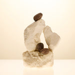 Decorative stone sculpture with a shea nut on top against a beige background