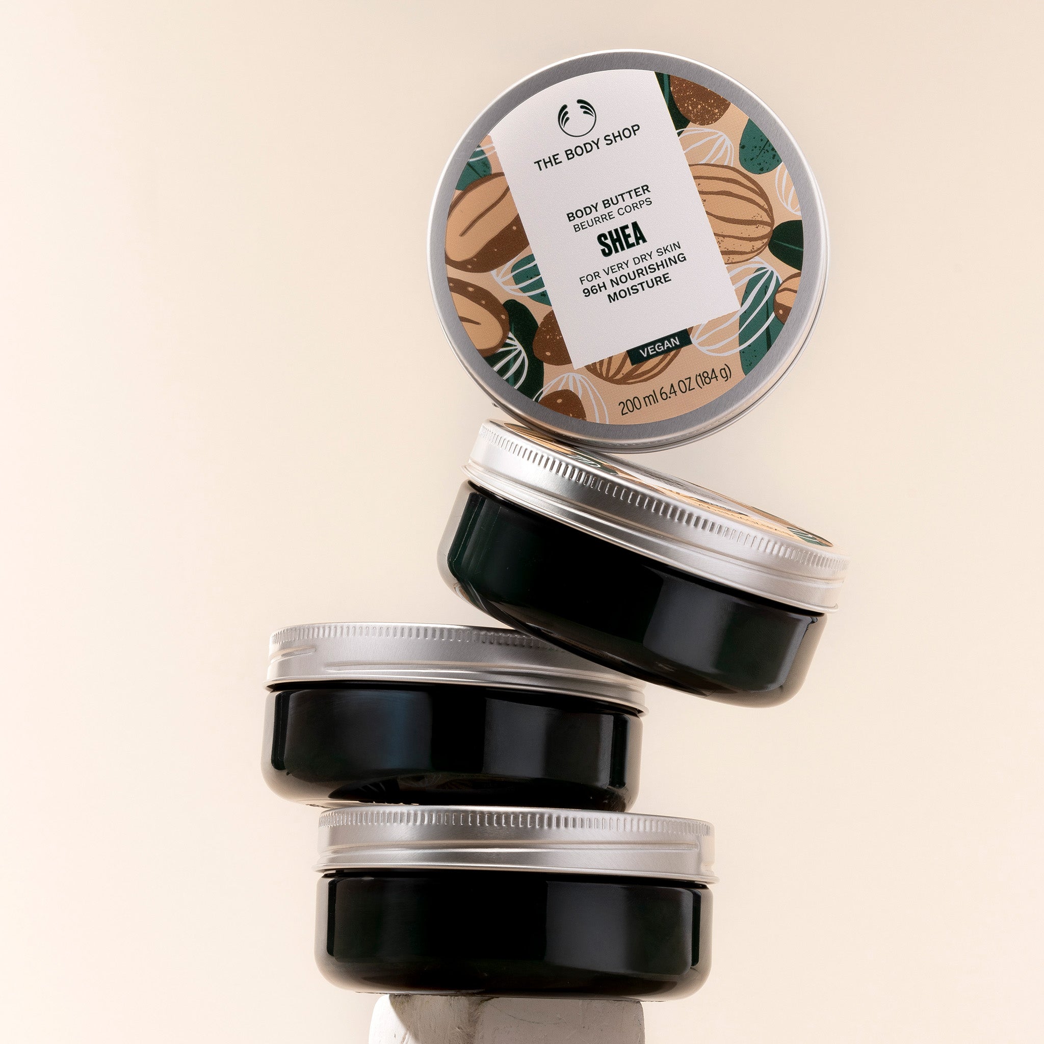 The Body Shop Shea body butter jars on a beige background