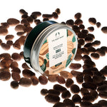 The Body Shop Shea body butter jar surrounded by shea nuts on a white background