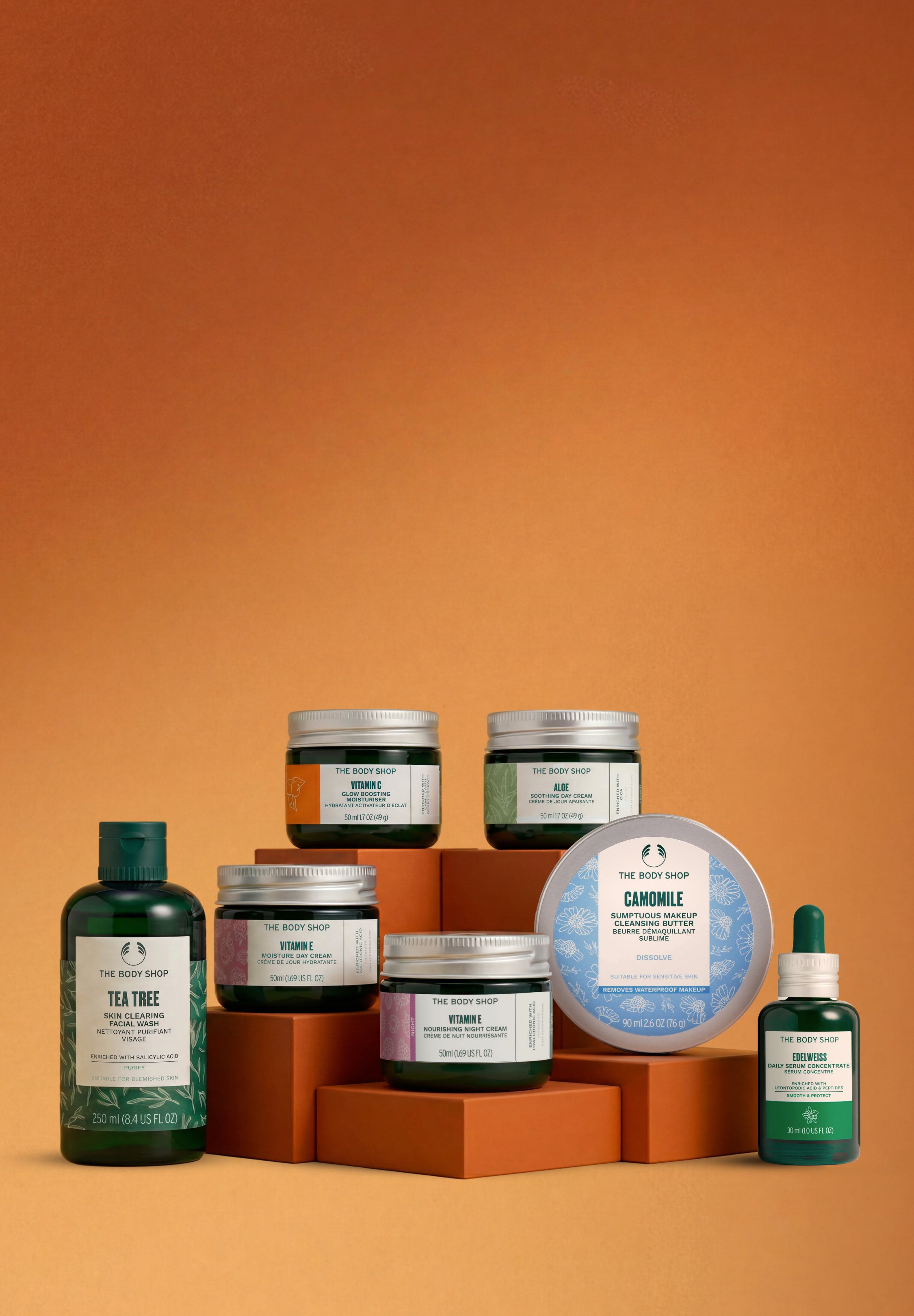 Collection of skincare products on an orange background