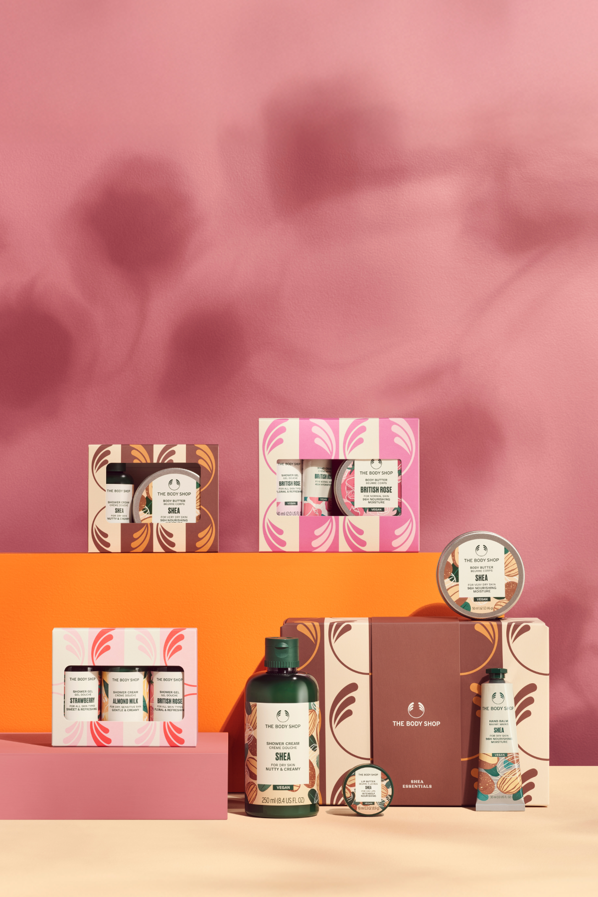 Collection of skincare products with decorative boxes on a pink and orange background