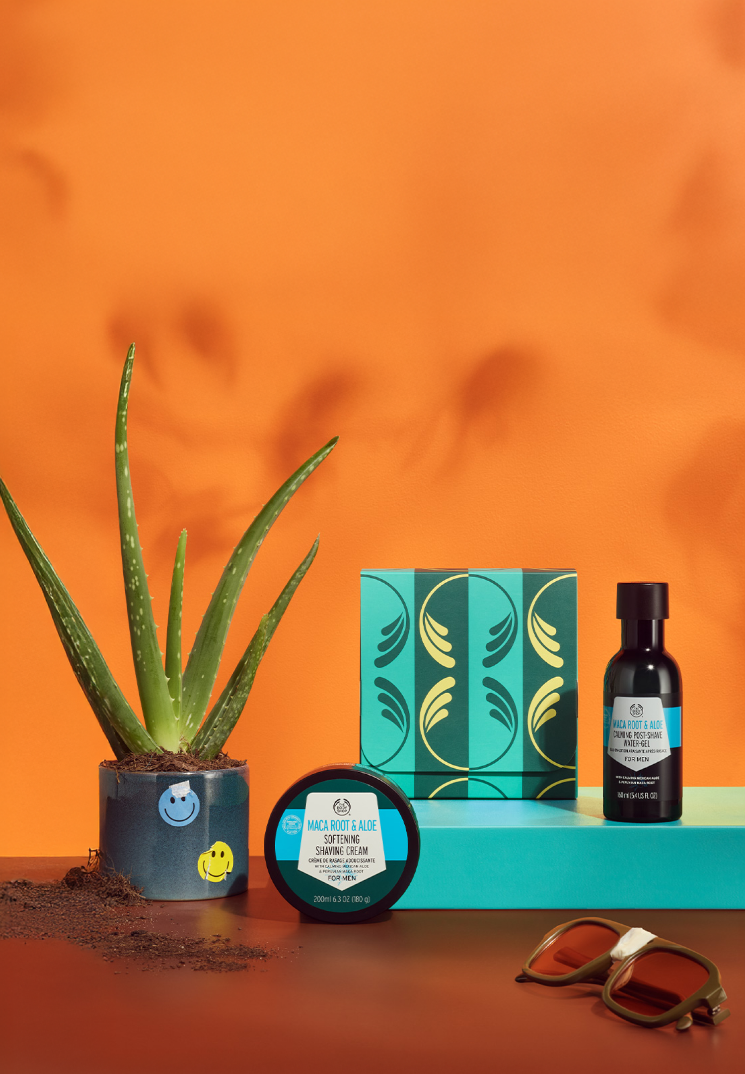Skincare products and aloe vera plant on an orange background