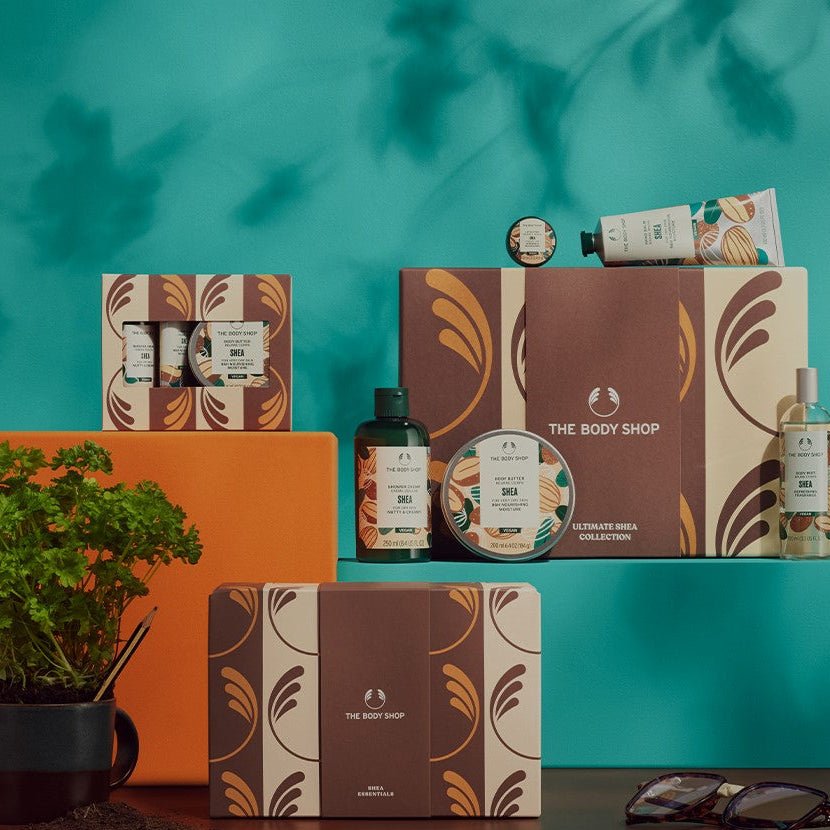 The Body Shop products on a teal background with an orange box and plant.