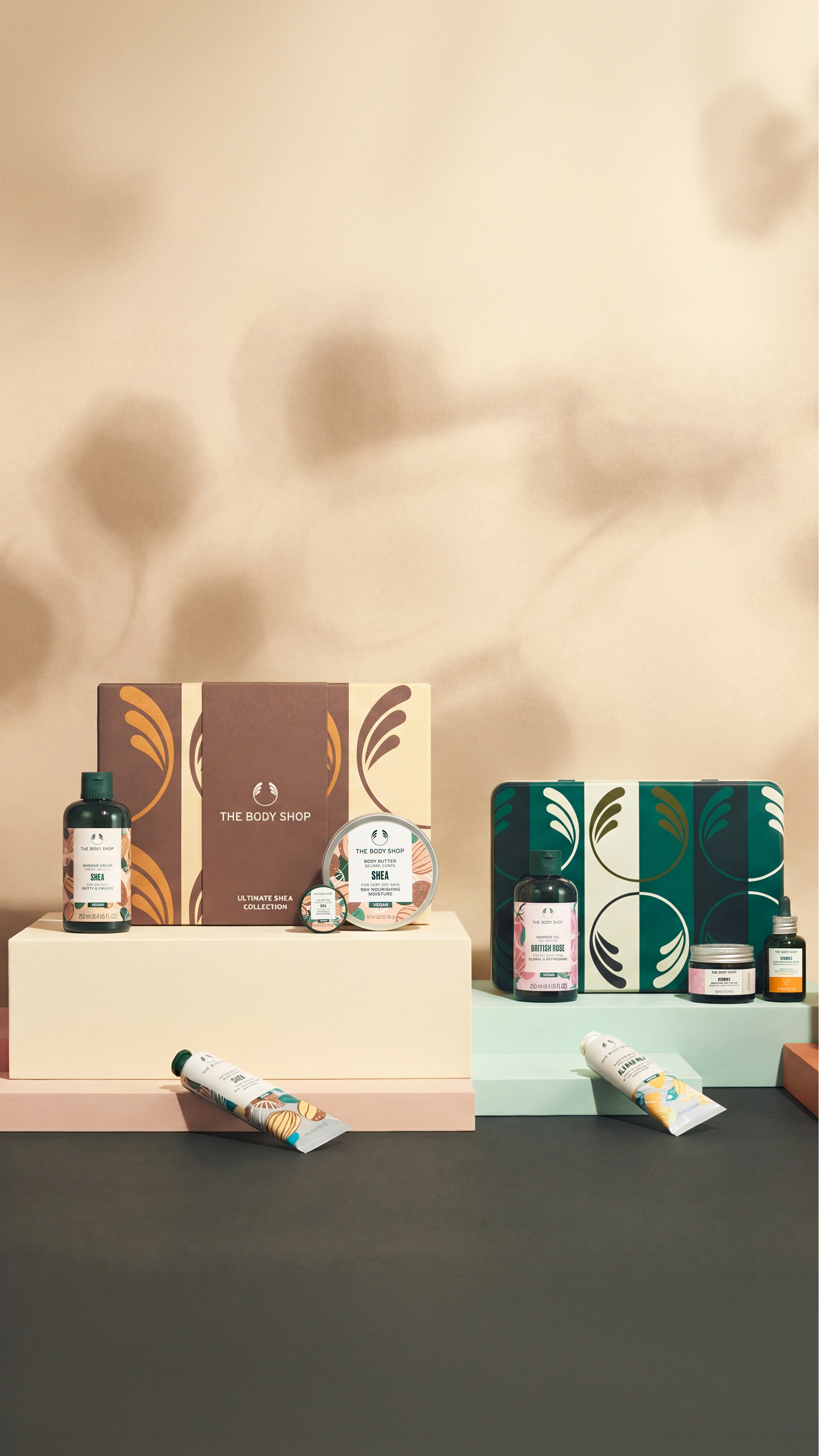 Collection of skincare products and boxes on a dark surface with a beige textured background